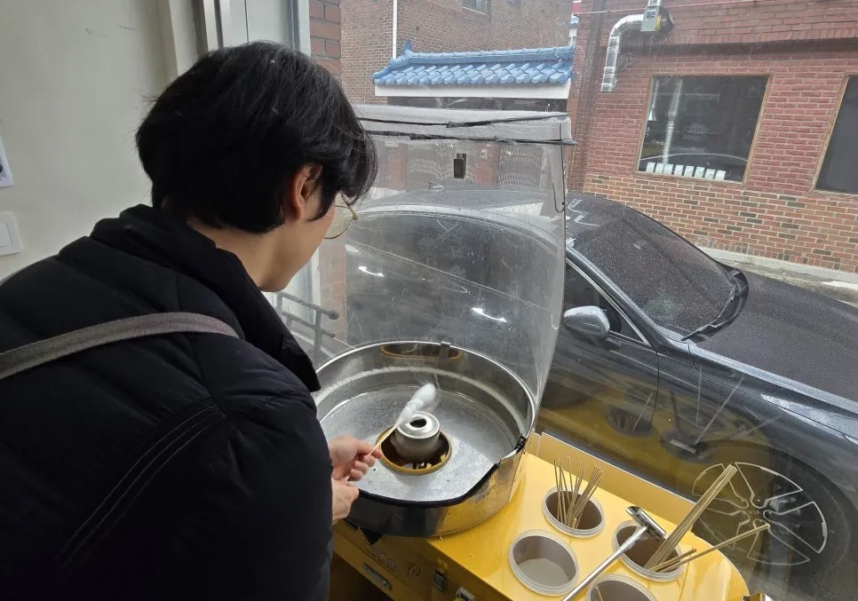 솜사탕 기계 앞에서 작동 상태를 살피는 교육 장면